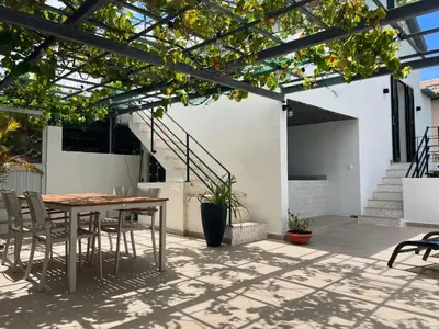 a patio with a table and chairs and stairs at Calheta Suites - Vinha & Jardim - Adults-only suites met hottub & zeezicht in Calheta