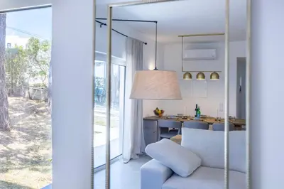 a living room with a blue chair and a kitchen at Alba Villa in Aljezur
