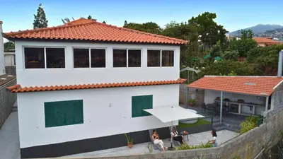 a white house with people standing outside of it at Serenity View by YOUR KEY in Funchal