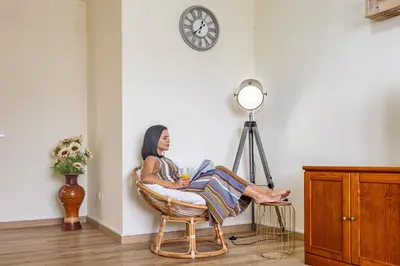a woman sitting in a chair under a clock at Serenity View by YOUR KEY in Funchal