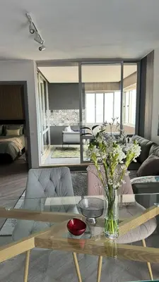 a living room with a table with a vase of flowers at Grayscale Studio in Caniço
