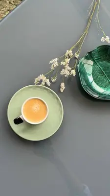 a cup of coffee on a plate next to a purse at Grayscale Studio in Caniço