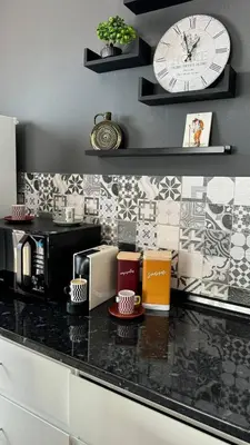 a kitchen with a counter with a clock on the wall at Grayscale Studio in Caniço