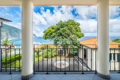 a view of the ocean from the balcony of a building at North Madeira Guesthouse in Seixal