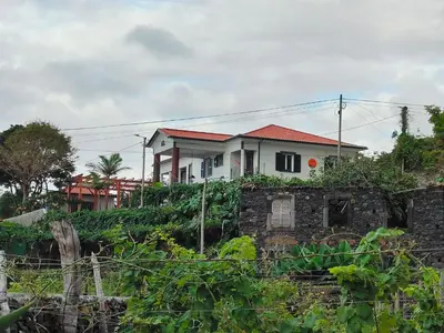 a white house on top of a hill at North Madeira Guesthouse in Seixal