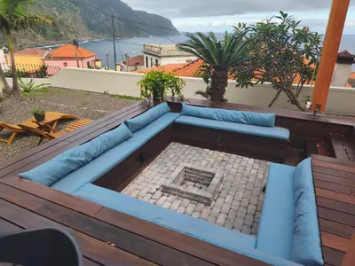 a blue couch sitting on top of a wooden deck at North Madeira Guesthouse in Seixal