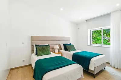 two beds in a white room with a window at The Oceanfront Villa Luz VR114 in Luz