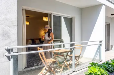 a woman standing on the balcony of a house at Secret Stay Funchal by YOUR KEY in Funchal