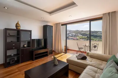 a living room with a couch and a large window at Lobos Horizon by An Island Apart in Câmara de Lobos