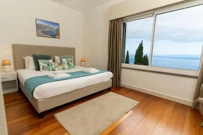 a bedroom with a bed and a large window at Villa Antonina by Madeira Real in Arco da Calheta