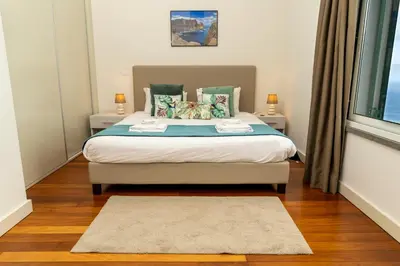 a bedroom with a bed with two tables and a window at Villa Antonina by Madeira Real in Arco da Calheta