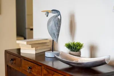 a statue of a bird on a desk with books at Villa Antonina by Madeira Real in Arco da Calheta