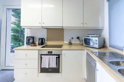 a kitchen with white cabinets and a sink and a microwave at Villa Antonina by Madeira Real in Arco da Calheta