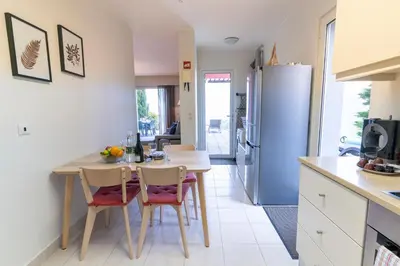 a kitchen with a table and chairs and a refrigerator at Villa Antonina by Madeira Real in Arco da Calheta