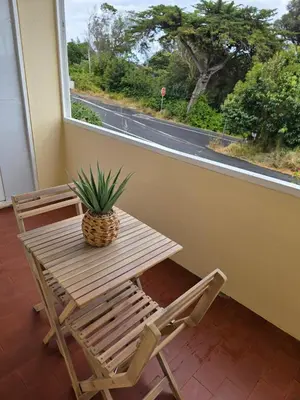 a wooden table and a chair next to a window at Apartment Matur View in Machico