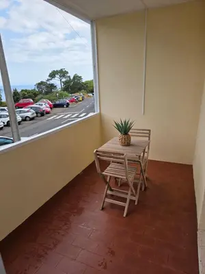 a table and chairs on a balcony with a window at Apartment Matur View in Machico