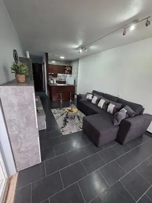 a living room with a couch and a kitchen at Apartment Matur View in Machico