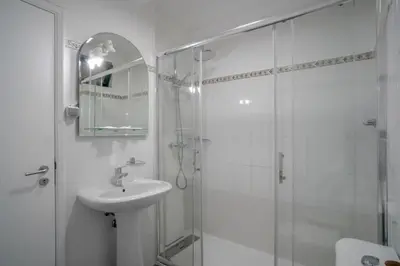 a white bathroom with a sink and a shower at Casa Giri in Relógio do Poiso