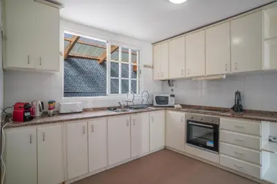 a kitchen with white cabinets and a window at Casa Giri in Relógio do Poiso