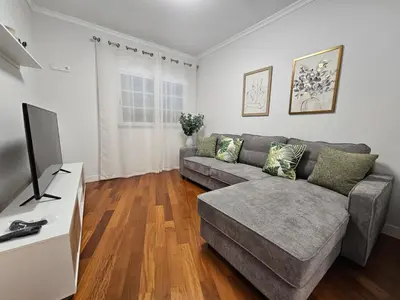 a living room with a couch and a tv at Santa Cruz Center by Rentallido in Santa Cruz