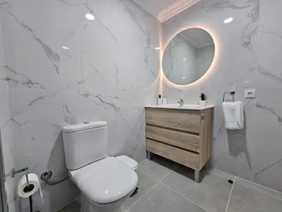 a bathroom with a toilet and a sink and a mirror at Santa Cruz Center by Rentallido in Santa Cruz