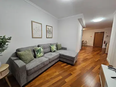a living room with a gray couch and wooden floors at Santa Cruz Center by Rentallido in Santa Cruz