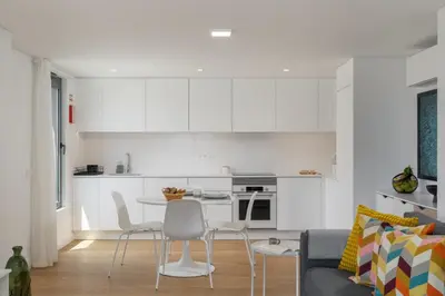 a kitchen with white cabinets and a table and chairs at Acqua Residence VIII by An Island Apart in Funchal