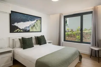 a bedroom with a bed and a large window at Acqua Residence VIII by An Island Apart in Funchal