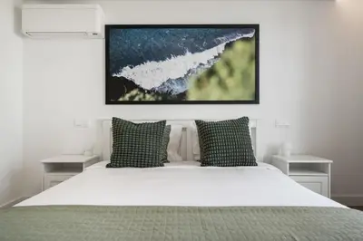 a bedroom with a white bed with two night stands at Acqua Residence VIII by An Island Apart in Funchal