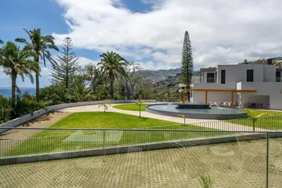 a tennis court in front of a house at Acqua Residence VIII by An Island Apart in Funchal