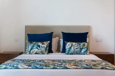 a large bed with blue pillows and blue pillows at Calheta Hills I by An Island Apart in Calheta