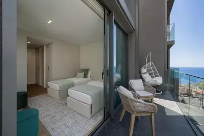 a bedroom with a bed and a balcony with a view at Calheta Hills I by An Island Apart in Calheta