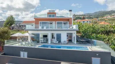 a house with a swimming pool on top of a building at Villa Oceano Sereno by GALMI in Ponta do Sol