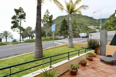 a balcony with palm trees and a street at Madalena Sunset by Mill Escapes in Madalena do Mar
