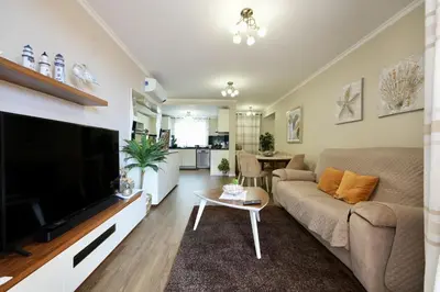 a living room with a large television and a couch at Madalena Sunset by Mill Escapes in Madalena do Mar