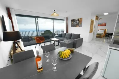 a living room with a couch and a television at CASA PANORAMA SOL- NEW VILLA WITH HEATED SALTWATER POOL and FANTASTIC SEA VIEW in Ponta do Sol