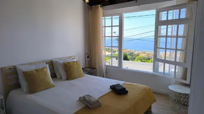 a bedroom with a bed and a large window at Consolação Sea View in Funchal