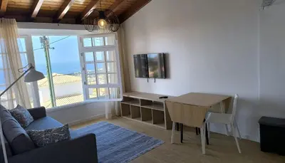 a living room with a couch and a table with a television at Consolação Sea View in Funchal
