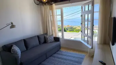 a living room with a blue couch and a large window at Consolação Sea View in Funchal