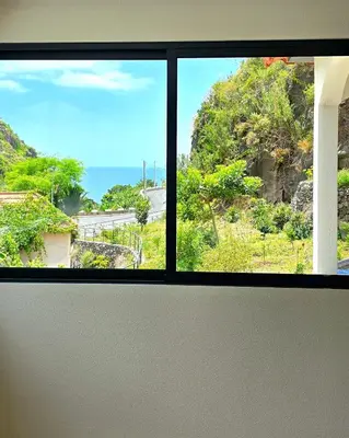 a window in a room with a view of the ocean at Annamoraj by Eurostay - Nature's peace - Your cozy escape! in Ribeira Brava