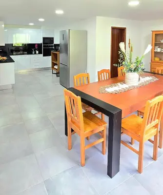 a kitchen and dining room with a wooden table and chairs at Annamoraj by Eurostay - Nature's peace - Your cozy escape! in Ribeira Brava