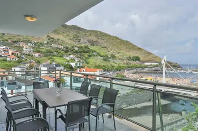 a parking lot with cars parked next to a beach at The Panoramic View Suites in Machico