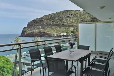 a living room with a table and a blue couch at The Panoramic View Suites in Machico