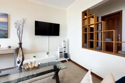 a living room with a couch and a table and windows at Ocean & Mountain Views-Garage Parking-Walk to Praia do Vigário in Câmara de Lobos