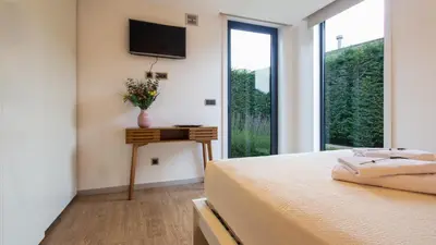 a bedroom with a bed and a television on the wall at The Jolie - A Retreat in the City in an Entire House in Funchal