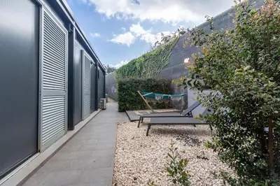 a garden with a bench and a house at The Jolie - A Retreat in the City in an Entire House in Funchal