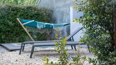 a hammock sitting on a bench in a garden at The Jolie - A Retreat in the City in an Entire House in Funchal
