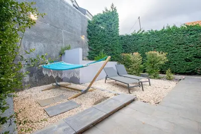 a hammock and a chair in a garden at The Jolie - A Retreat in the City in an Entire House in Funchal