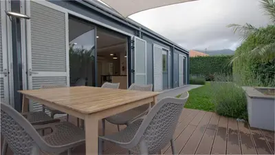 an outdoor patio with a wooden table and chairs at The Jolie - A Retreat in the City in an Entire House in Funchal