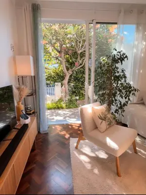 a living room with a white chair and a television at Sunny Double Room in 4BR Villa with AC, Sea View Balcony, Workspace in Funchal